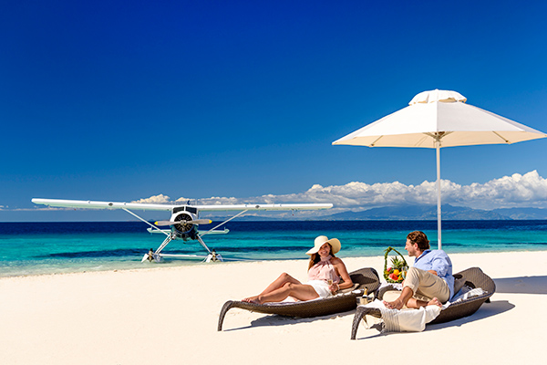 Couple on the beach with seaplane in background